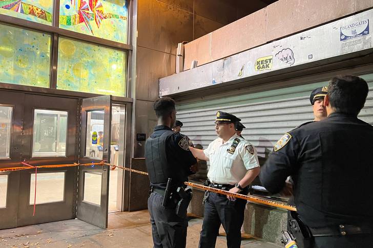 Police stand outside the Far Rockaway-Mott Avenue subway station in Queens hours after a 15-year-old boy was shot inside a subway car.